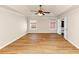 Bright bedroom featuring a tray ceiling, ceiling fan and wood-look flooring at 499 Bellbrook Ln, Lawrenceville, GA 30045