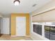 Sunny bedroom featuring a tan blind-covered window, white trim, and a bright yellow accent wall at 499 Bellbrook Ln, Lawrenceville, GA 30045