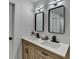 Modern bathroom featuring double sinks and sleek, black-framed mirrors at 5393 Ridge Forest Dr, Stone Mountain, GA 30083