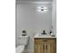 Modern half bathroom with a wood grain vanity, quartz countertop, and stylish light fixture at 5393 Ridge Forest Dr, Stone Mountain, GA 30083