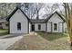 Charming one story home with white siding, black trim and a concrete driveway at 5393 Ridge Forest Dr, Stone Mountain, GA 30083