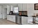 Well-lit kitchen featuring sleek countertops, white cabinets, and stainless steel dishwasher at 5393 Ridge Forest Dr, Stone Mountain, GA 30083