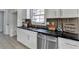 Well-lit kitchen featuring sleek countertops, white cabinets, and stainless steel dishwasher at 5393 Ridge Forest Dr, Stone Mountain, GA 30083