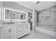 Bathroom with double sinks, illuminated mirror, tub and shower, and neutral tile design at 609 Old Wheat Ne St, Atlanta, GA 30312