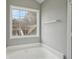 Bathroom featuring a soaking tub and a large window bringing in natural light at 1542 Bogota Way, Jonesboro, GA 30236