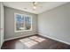 Cozy bedroom featuring wood floors and a large window offering ample natural light at 1542 Bogota Way, Jonesboro, GA 30236