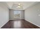 Large bedroom with hardwood floors, a ceiling fan, tray ceiling, and a large window at 1542 Bogota Way, Jonesboro, GA 30236