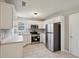 Well-lit kitchen boasting tile floors, white cabinets, and stainless steel appliances at 1542 Bogota Way, Jonesboro, GA 30236