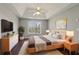 Stylish main bedroom with wood floors, tray ceiling, ceiling fan, and a well-lit sitting area at 1542 Bogota Way, Jonesboro, GA 30236