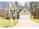 Two-story home with a two-car garage, showcasing a neat front lawn and trimmed bushes by the entrance at 3045 Arden Ridge Dr, Suwanee, GA 30024