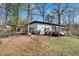 Backyard with a large wooden deck and chain link fence. Trees and some lawn at 629 Moselle Sw Dr, Mableton, GA 30126