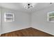 Empty bedroom featuring hardwood floors, white walls, and two windows for natural light at 629 Moselle Sw Dr, Mableton, GA 30126