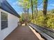 View of a spacious wooden deck surrounded by lush trees, offering ample seating at 629 Moselle Sw Dr, Mableton, GA 30126