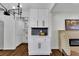 Bright butler's pantry with white cabinets, modern black hardware, and matching backsplash and chandelier at 629 Moselle Sw Dr, Mableton, GA 30126