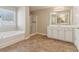 Bright bathroom featuring a tub, separate shower, vanity, and tile flooring at 3255 Blackburn Dr, Cumming, GA 30040