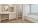 Bright bathroom with vanity and sink, tile flooring, and a view of the bathtub at 3255 Blackburn Dr, Cumming, GA 30040