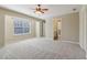 This spacious bedroom features plush gray carpeting, a ceiling fan, and a doorway that leads into the bathroom at 3255 Blackburn Dr, Cumming, GA 30040