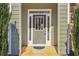 Close up of the front door with sidelights, transom window, and trimmed green shrubbery at 3255 Blackburn Dr, Cumming, GA 30040