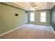 Spacious bedroom with neutral carpet, traditional floral wallpaper, and natural light from two windows at 5150 Rockford Ln, Stockbridge, GA 30281