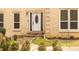 Close up of front door with stone steps, blooming flowers, and manicured shrubs at 5150 Rockford Ln, Stockbridge, GA 30281