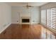 Living room with hardwood floors, a fireplace, white shutters, and crown molding at 5150 Rockford Ln, Stockbridge, GA 30281