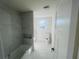 Bright bathroom featuring a tiled shower-tub, white fixtures, and a window offering natural light at 53 Springside Se Dr, Atlanta, GA 30354