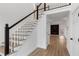 Bright entryway featuring hardwood floors, staircase with white railings and black accents, and neutral-toned walls at 816 Ivy Ridge Dr, Loganville, GA 30052