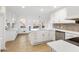Bright, white kitchen featuring updated cabinets, countertops, and backsplash, as well as hardwood floors at 816 Ivy Ridge Dr, Loganville, GA 30052