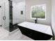 The bathroom features a modern glass shower, tub, and sleek vanity with modern fixtures and finishes at 2143 Lyle Ave, College Park, GA 30337