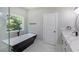 Modern bathroom features a freestanding tub, white marble floors, and a sleek single sink vanity at 2143 Lyle Ave, College Park, GA 30337