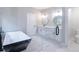 Bathroom with a glass shower, black and white tub and double vanity with marble countertops at 2143 Lyle Ave, College Park, GA 30337