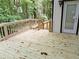 Unstained wood deck with wooden railings leads to a back door with beautiful green scenery at 2143 Lyle Ave, College Park, GA 30337