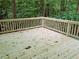 Unstained wood deck with wooden railings overlooks a lush, green, wooded backyard at 2143 Lyle Ave, College Park, GA 30337