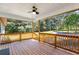 Covered back porch with wood flooring and railings, providing a scenic view of the surrounding trees and landscape at 4739 Cook Sw Rd, Stockbridge, GA 30281