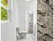 Bathroom featuring a modern marble shower, stylish fixtures, and natural light, adjacent to the toilet and a closet at 4739 Cook Sw Rd, Stockbridge, GA 30281