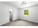 Bedroom showcasing neutral carpeting, white walls, modern light fixture, closet, and natural light from the window at 4739 Cook Sw Rd, Stockbridge, GA 30281