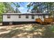 Exterior of a home featuring a deck and lawn with mature trees and shrubs at 4739 Cook Sw Rd, Stockbridge, GA 30281