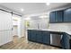 Bright kitchen boasts blue cabinets, a barn door to a pantry, and stainless steel appliances at 4739 Cook Sw Rd, Stockbridge, GA 30281