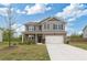 Two-story home boasts a lush lawn, long driveway, and attached garage with a beautiful blue sky at 4825 Layton Drive, Lithia Springs, GA 30122