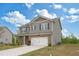 Two-story home boasts a lush lawn, long driveway, and attached garage with a beautiful blue sky at 4825 Layton Drive, Lithia Springs, GA 30122