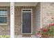 Inviting front entrance features a classic dark door and brick facade with address numbers on the pillar at 4825 Layton Drive, Lithia Springs, GA 30122