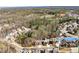 Overhead view of the home in a wooded neighborhood with a pond nearby at 1351 Ashbury Park Dr, Hoschton, GA 30548
