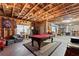 Unfinished basement features exposed wood and a pool table at 1351 Ashbury Park Dr, Hoschton, GA 30548