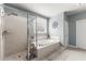 Modern bathroom featuring a glass shower and a soaking tub by a window, creating a spa-like ambiance at 1351 Ashbury Park Dr, Hoschton, GA 30548