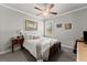 Cozy bedroom features a plush bed, ceiling fan, bedside table, and neutral décor at 1351 Ashbury Park Dr, Hoschton, GA 30548