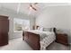 Bedroom with a coffered ceiling, a ceiling fan, a large window, and a wood furniture set at 1351 Ashbury Park Dr, Hoschton, GA 30548