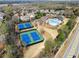Aerial view of tennis courts and a community pool surrounded by lush landscaping and beautiful homes at 1351 Ashbury Park Dr, Hoschton, GA 30548