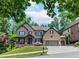 Stunning two-story brick home with a three-car garage and well-manicured lawn at 1351 Ashbury Park Dr, Hoschton, GA 30548