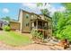 Charming home exterior features a covered patio, a lush yard with landscaping, and an outdoor fire pit area at 1351 Ashbury Park Dr, Hoschton, GA 30548
