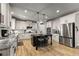 Kitchen features white cabinets, an island with seating, and stainless steel appliances at 1351 Ashbury Park Dr, Hoschton, GA 30548